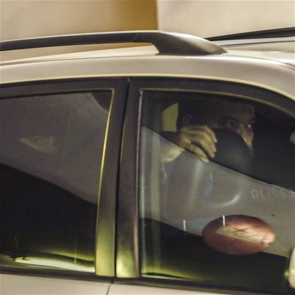 Christos Pappas, partitopp i Gyllene Gryning, sitter i en bil mellan maskerade poliser