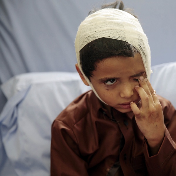 Ett barn i en sjukhussäng, med bandage runt huvudet.
