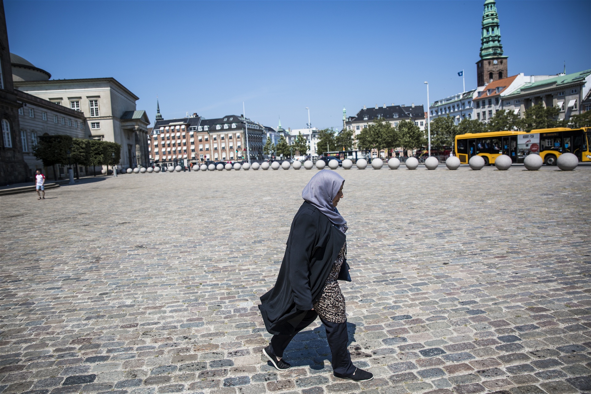 Rihab Kassem går över torget utanför Christiansborg.