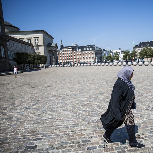 Rihab Kassem går över torget utanför Christiansborg.