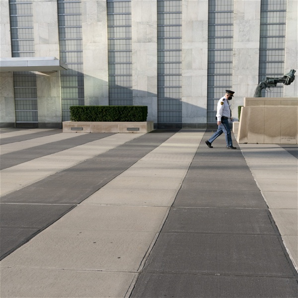 En man passerar utanför FN:s högkvarter. En skulptur av en pistol med pipan ihopknuten till en knut syns.