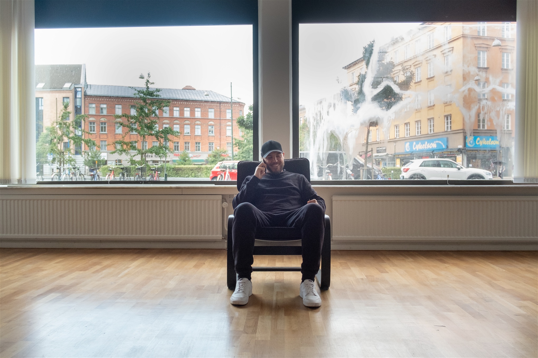 Nicolas Lunabba sittande i en fåtölj i ett tomt rum med utsikt över Möllevången.
