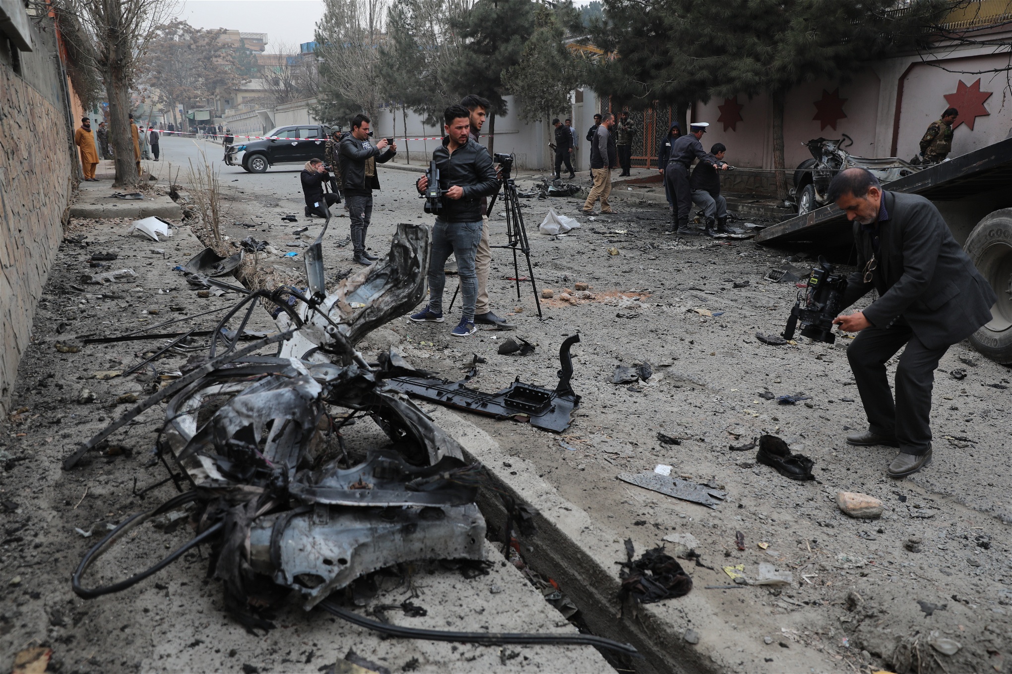Journalister filmar och fotar på en explosionsplats i Kabul.