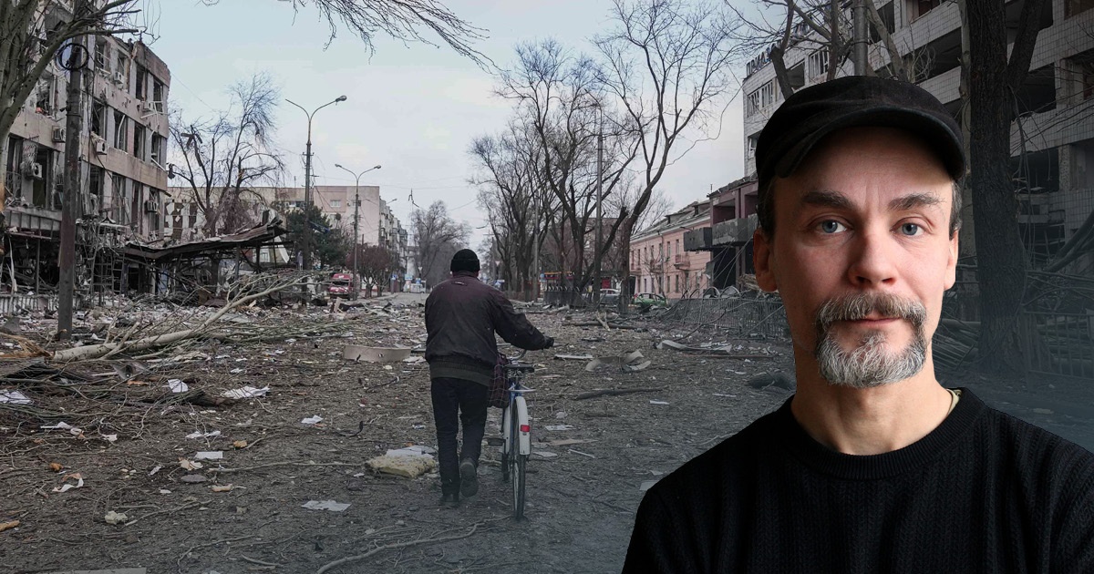 Emil Boss i svart tröja och keps mot en utbombad väg i ukraina med en ensam man som går i mitten