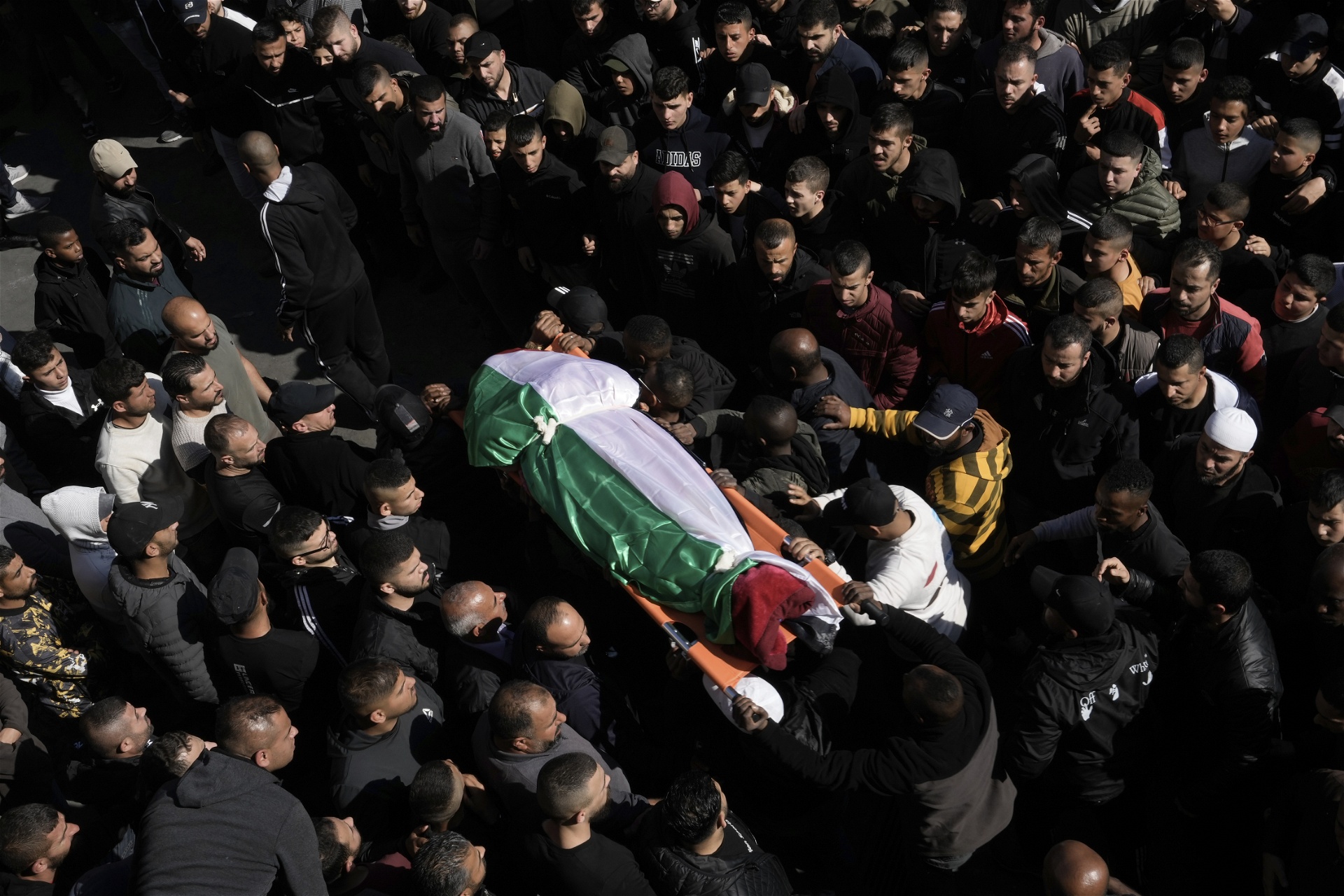Sörjande samlas i staden Jenin på det ockuperade Västbanken för att begrava den 60-åriga palestinska kvinnan Magda Obaid som dödades av israelisk militär på torsdagen. Minst nio palestinier dödades vid attacken mot ett flyktingläger, vilket beskrivs som det dödligaste attentatet av Israels militär på flera månader. Foto: Majdi Mohammed/AP/TT