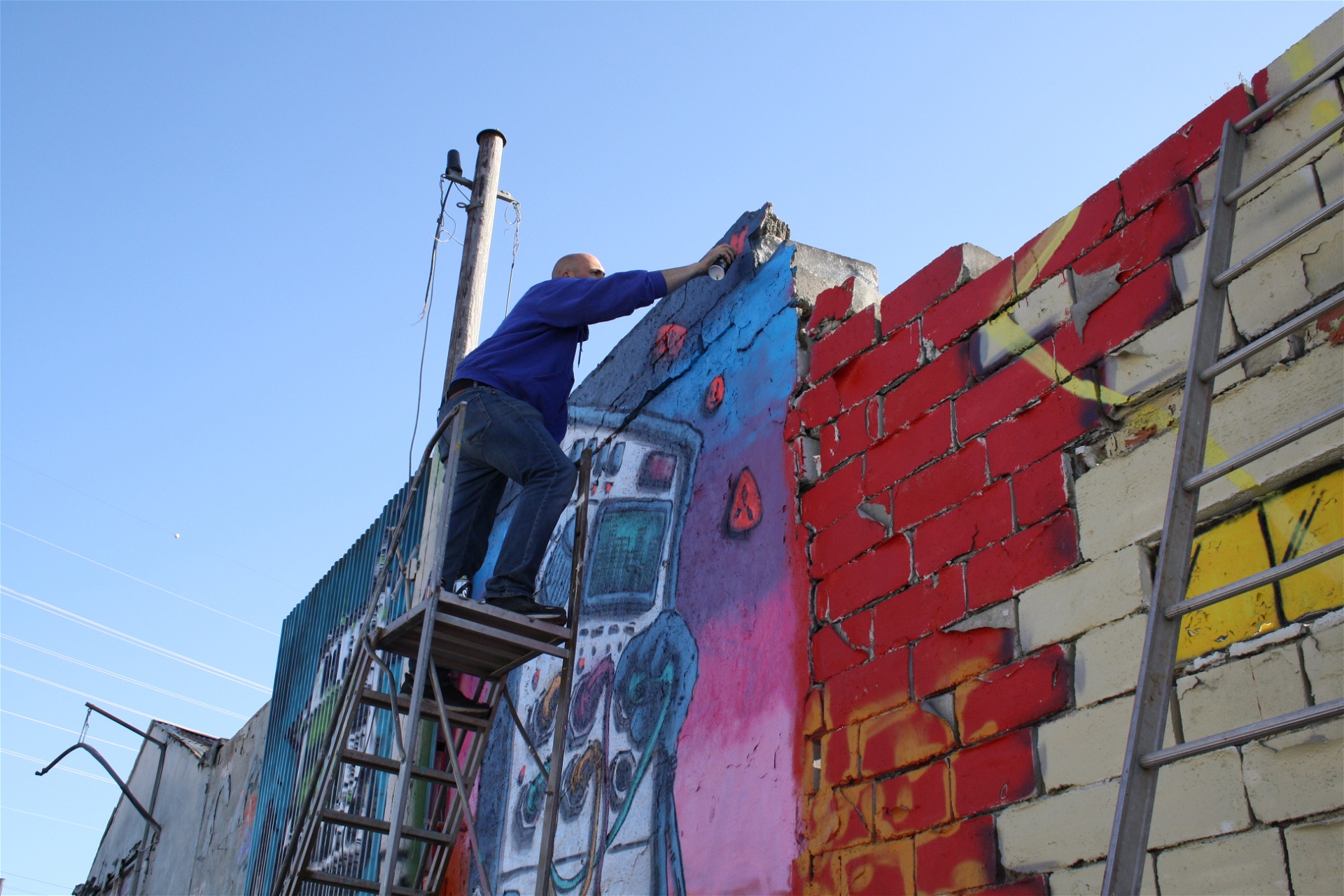 Gatukonstnären Good mood målar en väggmålning på graffitifestivalen Spring Beast i Snösätra.