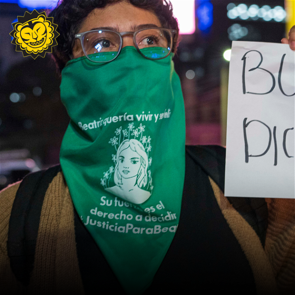 Aktivist i El Salvador med grön sjal över munnen och skylt där det står Bukele diktator.