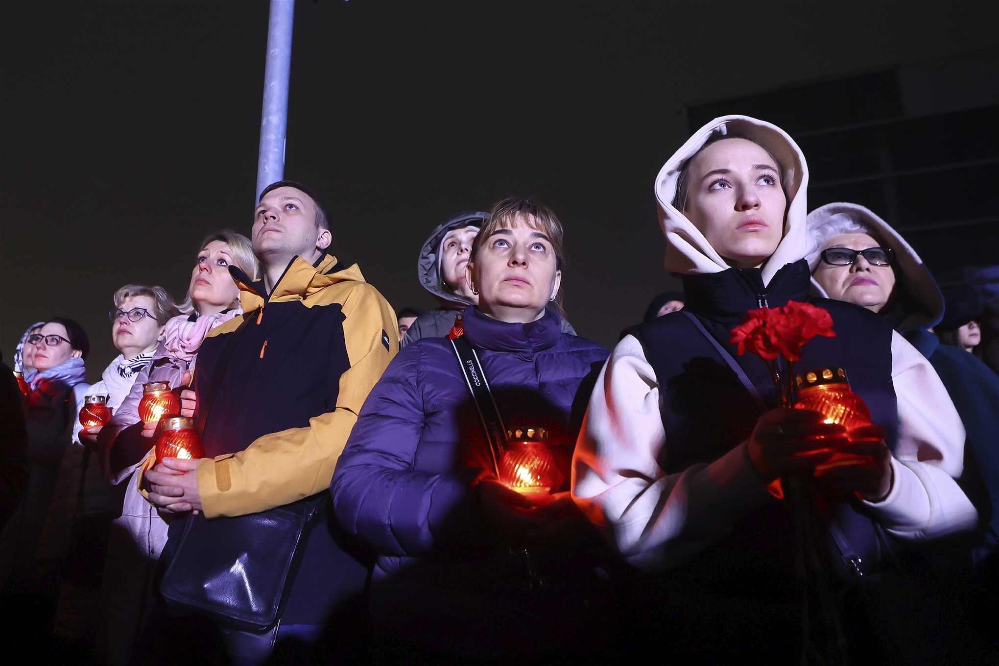 En grupp sörjande personer håller ljus i händerna till minnet av de dödade i attentatet på en teater i Moskva