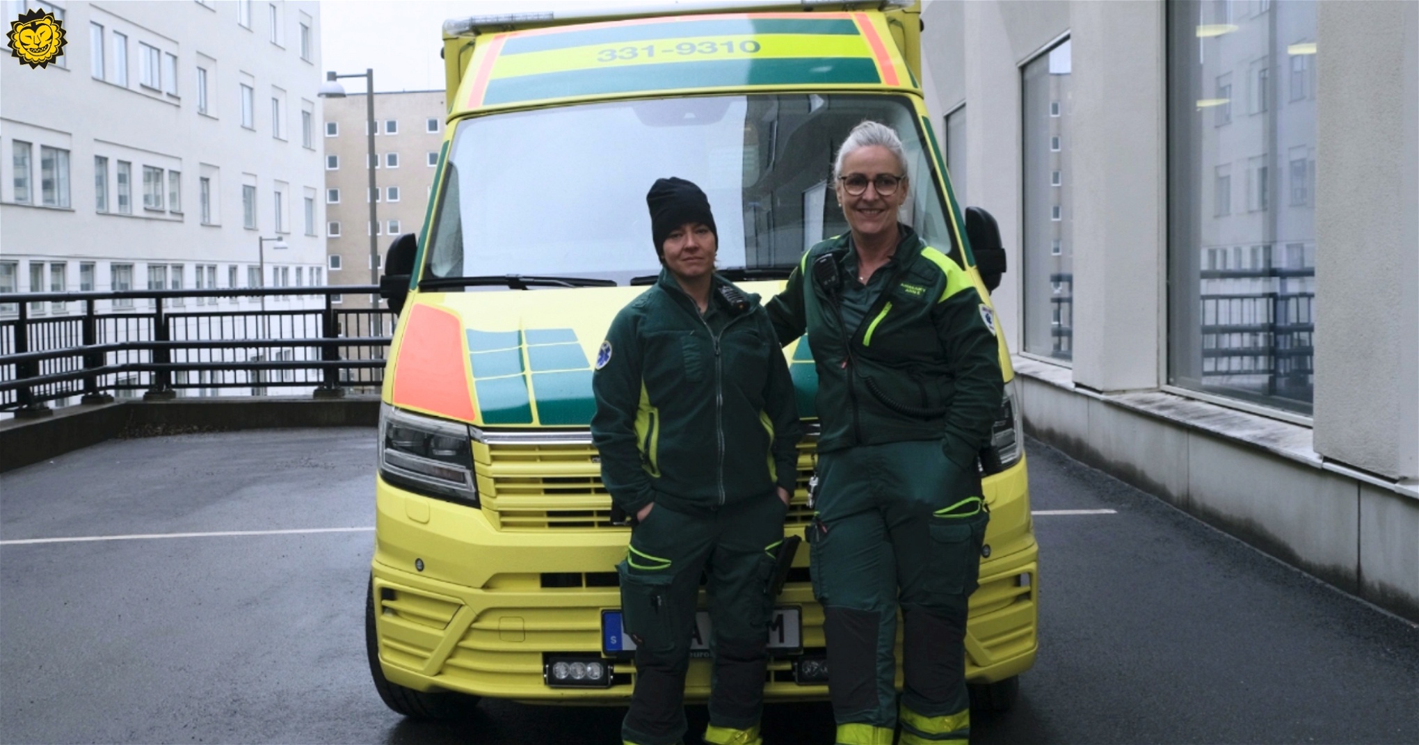 Två ambulansförare framför en ambulans.