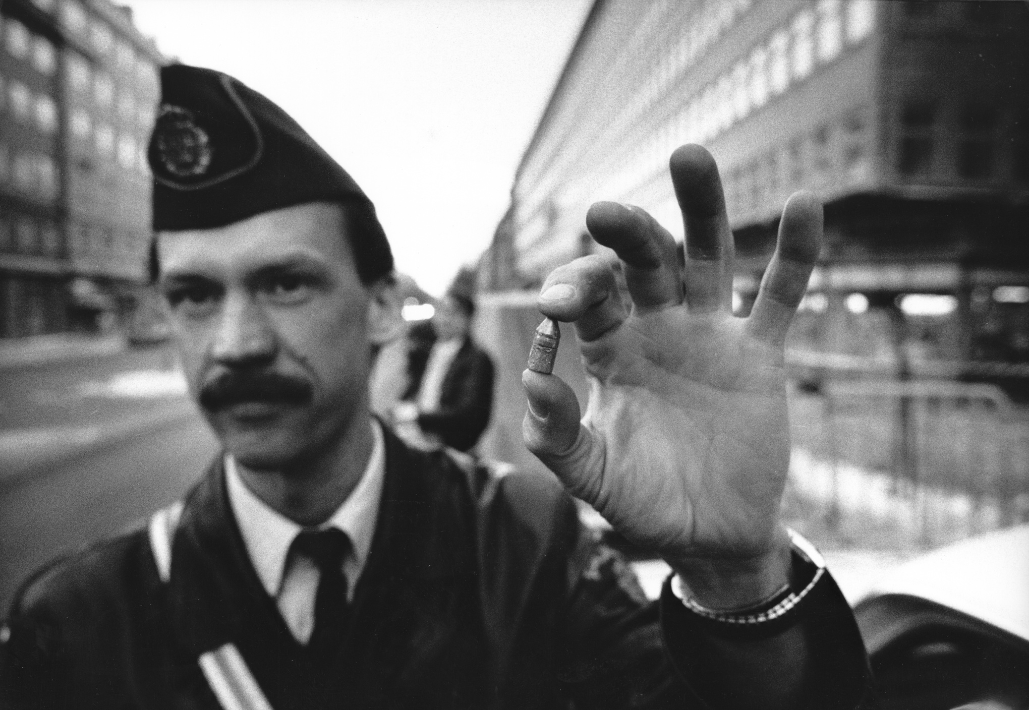 Polisinspektör Bo Larsson håller upp en grovkalibrig kula som hittats på trottoaren på andra sidan Sveavägen av allmänheten, dagen efter mordet på Olof Palme.