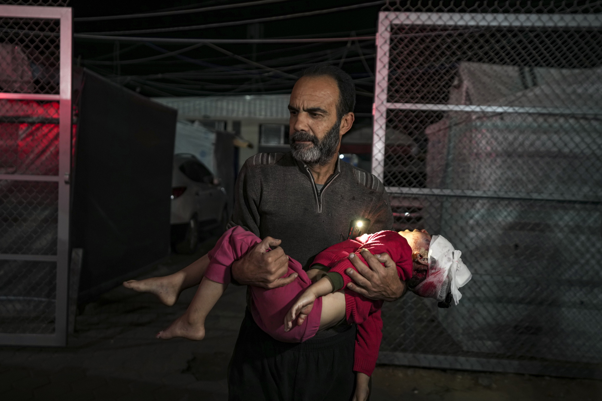 En palestinsk man bär på en skadad anhörig i Gaza