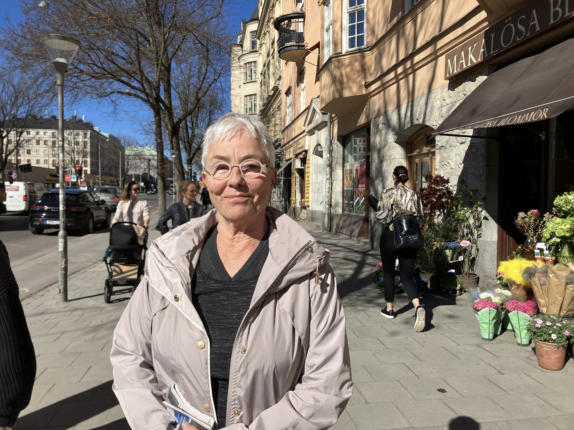 Catharina Calleman, professor emirita i arbetsrätt, står i solen på trottoaren längs Sveavägen
