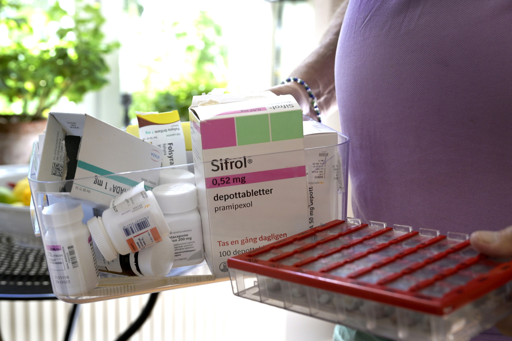 En person som håller i en låda fylld med mediciner.