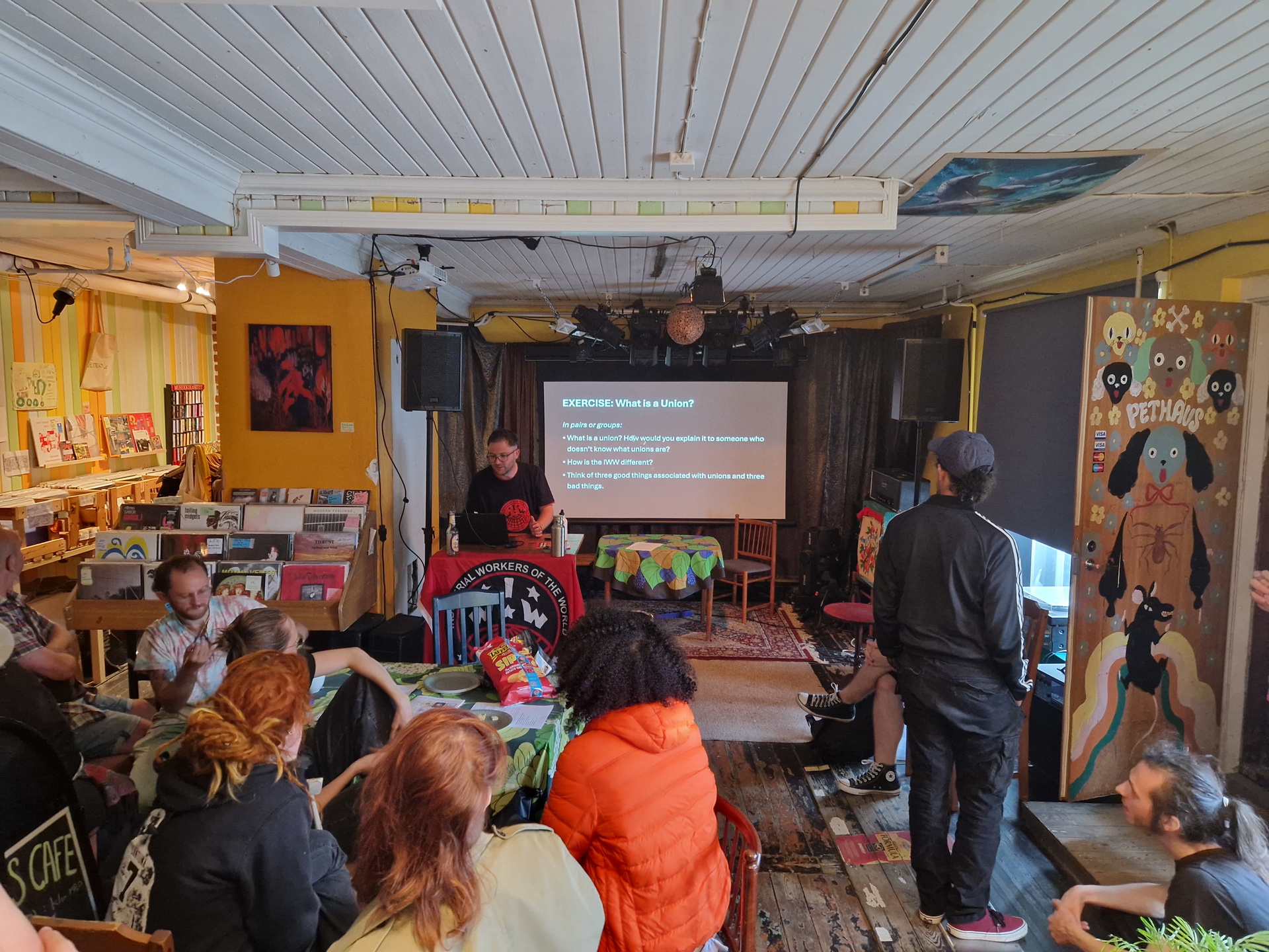 Cirka 10 personer tittar på workshophållaren som visar en powerpoint med rubriken What is a union?