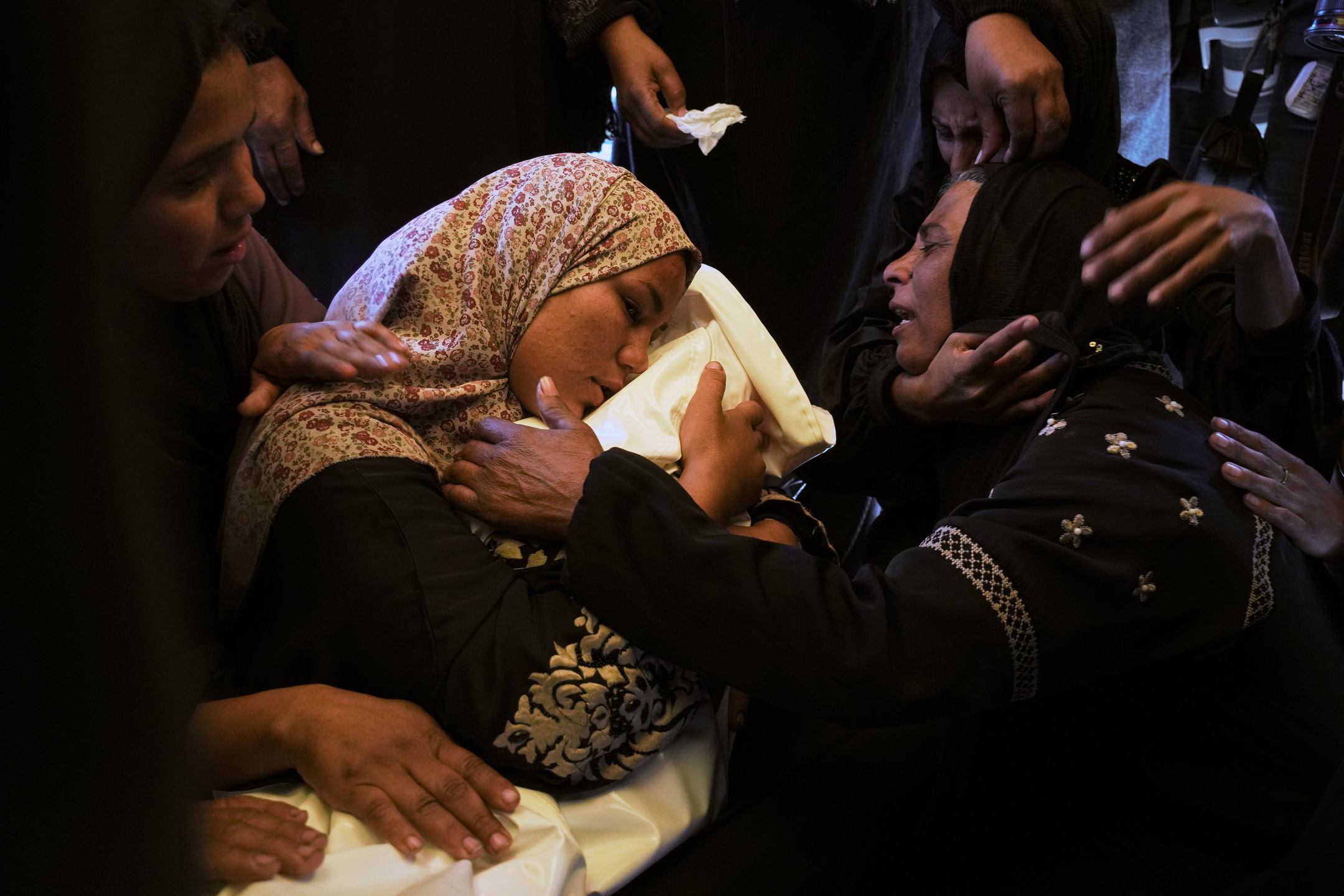 En mor sörjer sitt dödade barn efter att Israel attackerat ett tältläger i södra Gaza tidigare i veckan.